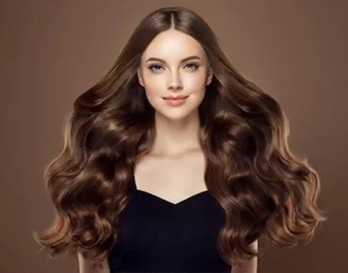 A woman with long hair wearing black top posing in front of camera